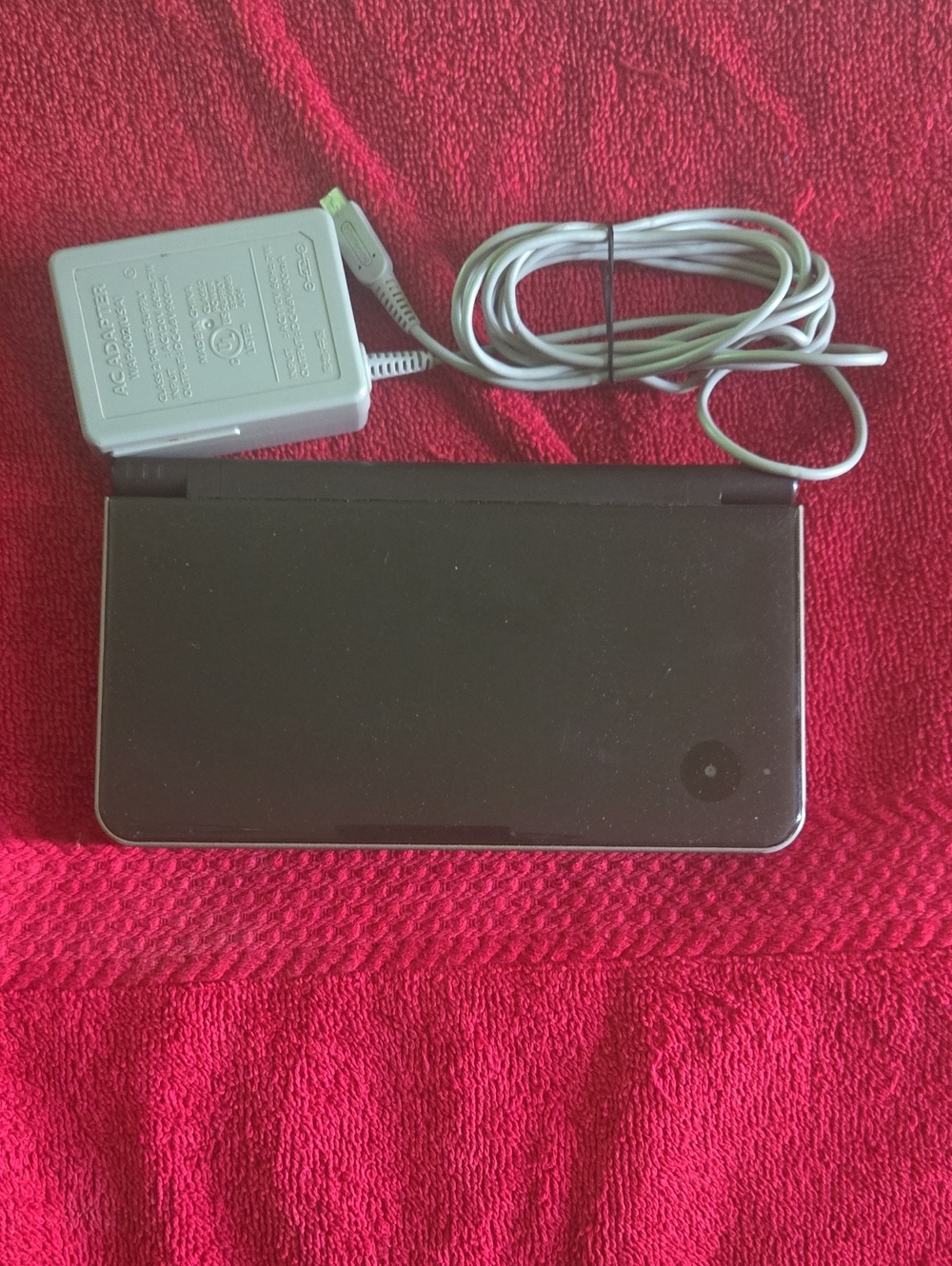 Nintendo DSi XL in black with minor scrapes and scratches